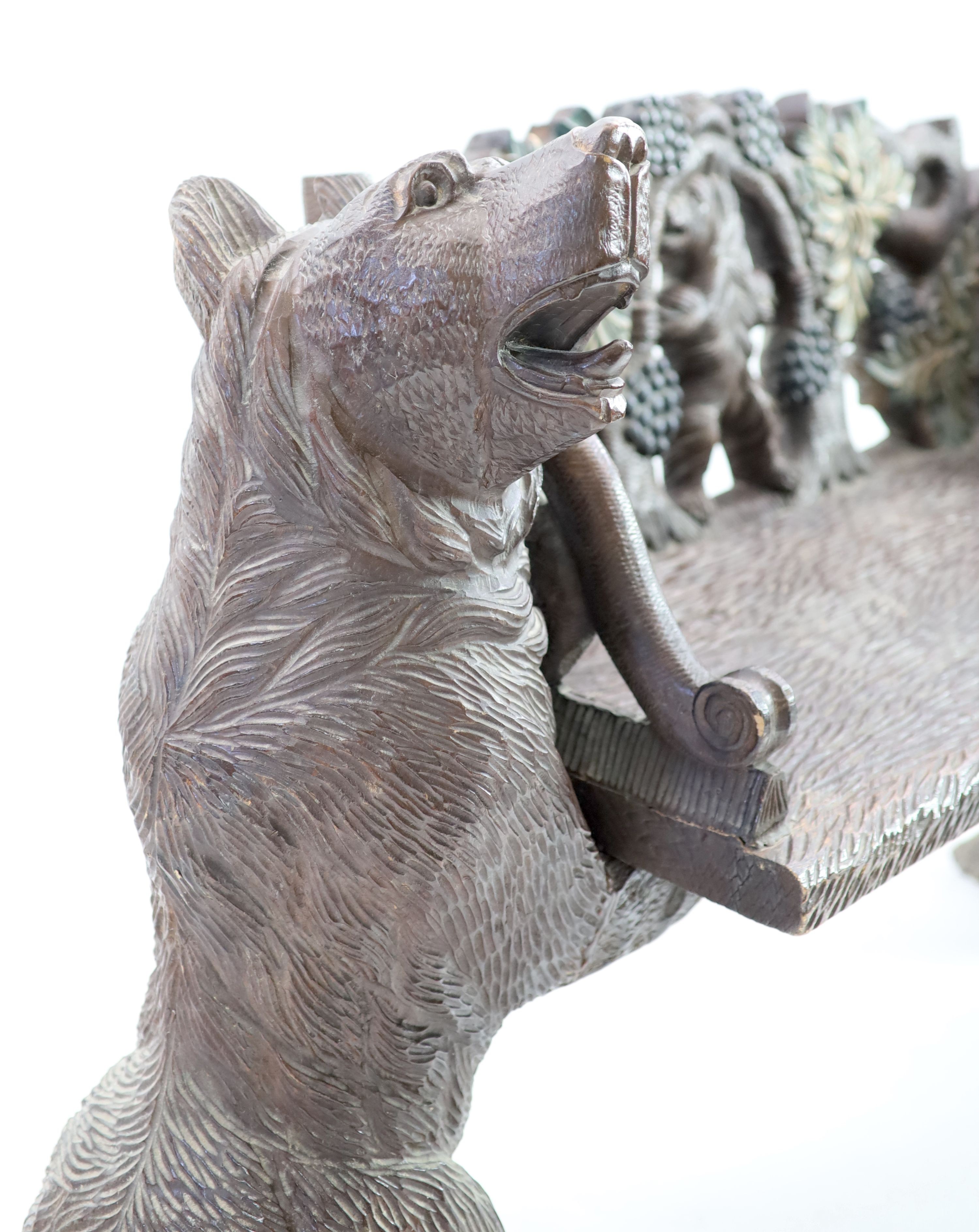 An early 20th century Black Forest carved wood bear hall seat, W.162cm D.52cm H.95cm